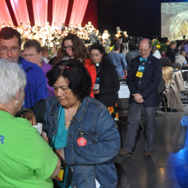 a group of people approach a volunteer for communion elements